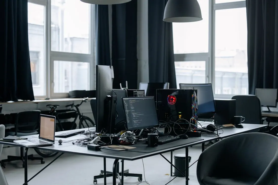 Modern tech company office with computers and code screens, representing the scene of an AI incident.
