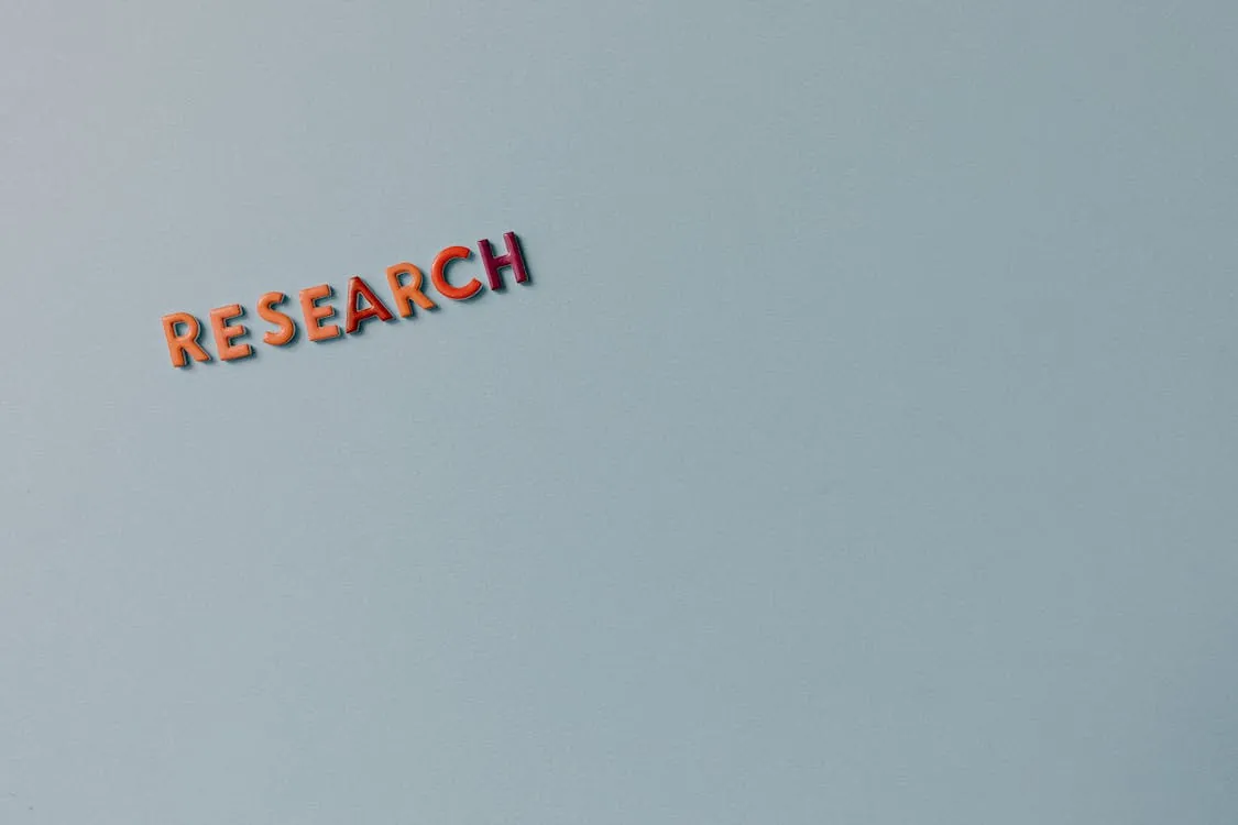 Minimalist image with the word 'RESEARCH' in colorful letters on a plain background, representing research methodology in artificial intelligence.