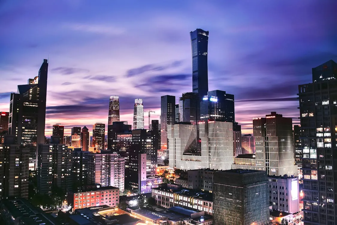 Explore the vibrant skyline of Beijing as twilight paints the horizon in this stunning aerial shot.