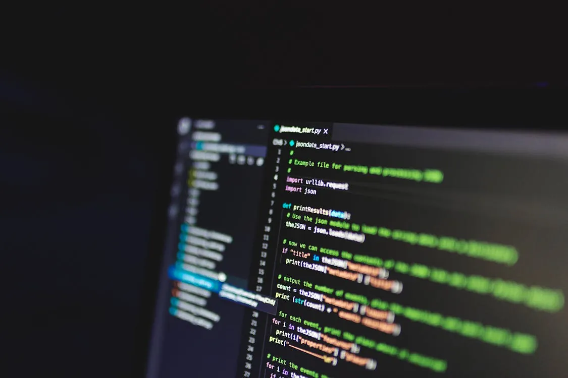 This photo shows a close-up of a computer screen displaying a Python programming script with syntax highlighting, set against a dark background. It would suit a blog post about programming, coding tutorials, or software development topics.