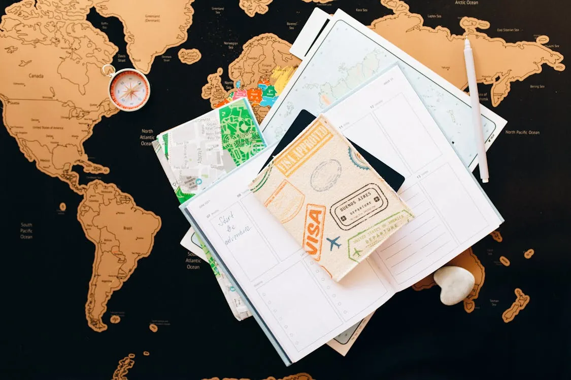 Flat lay of travel planning items on a map, representing comparison of digital nomad visas with citizenship paths.
