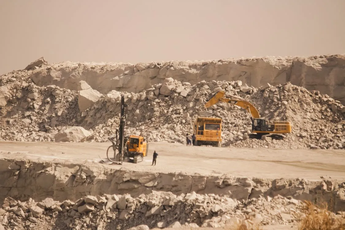 Heavy equipment operating in a quarry or mining site, representing resource extraction and development