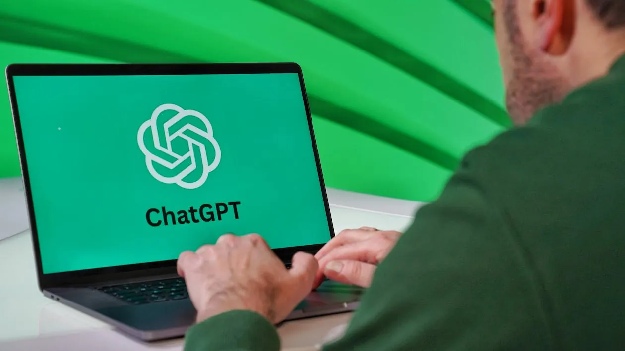 Person using laptop with ChatGPT logo