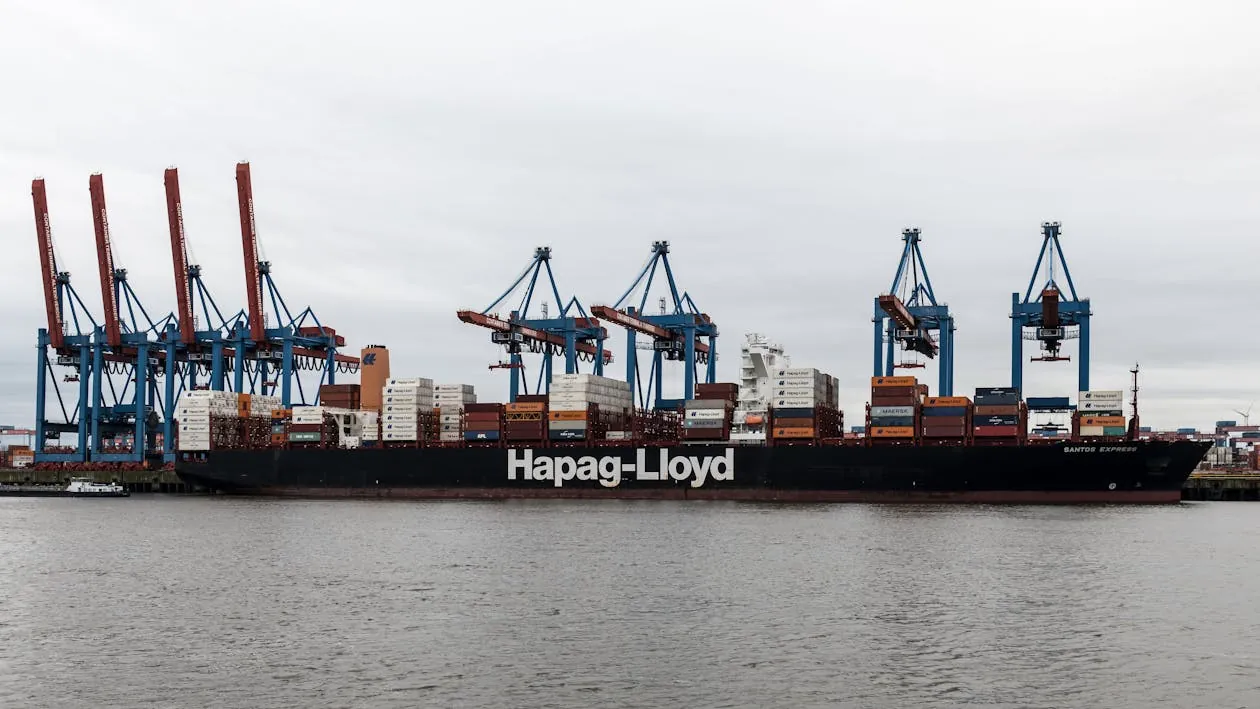 Large container ship docked at Hamburg port with cranes