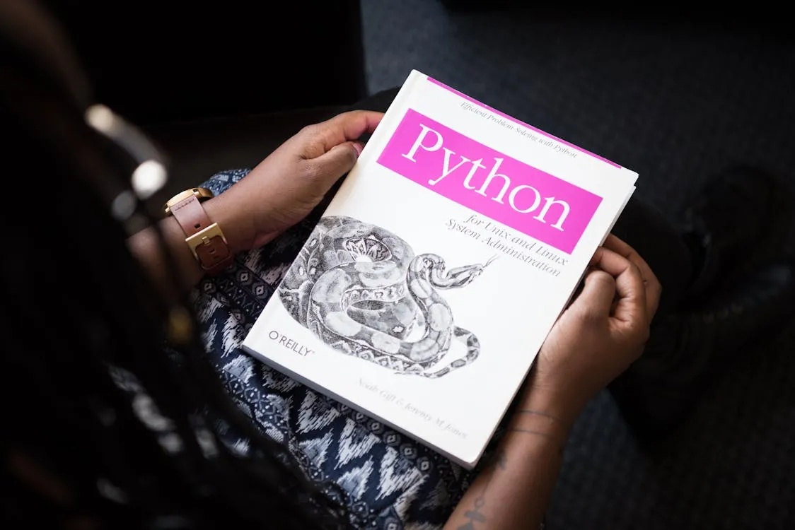 Person holding a Python programming book