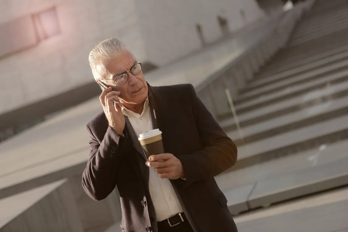 Business leader on phone outside modern building
