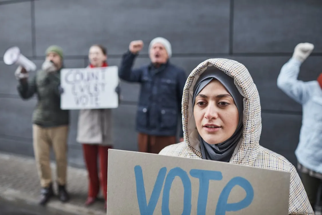 A diverse group of people at a peaceful street protest, symbolizing the debate over residency and citizenship changes in Latin America for 2026.