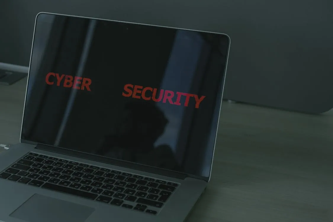 This image shows a laptop on a desk with the words "CYBER SECURITY" displayed prominently on its screen, highlighting themes related to online safety, cybersecurity, and digital protection, making it suitable for articles on cybersecurity awareness or digital security measures.
