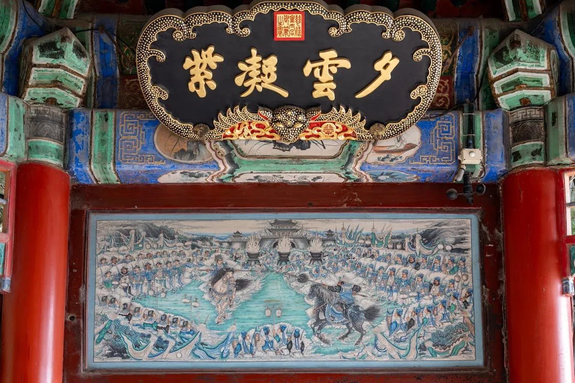 Intricate artwork and calligraphy adorn the ceiling of a historic Chinese temple, representing the Tang Dynasty's golden age of openness and cultural flourishing.