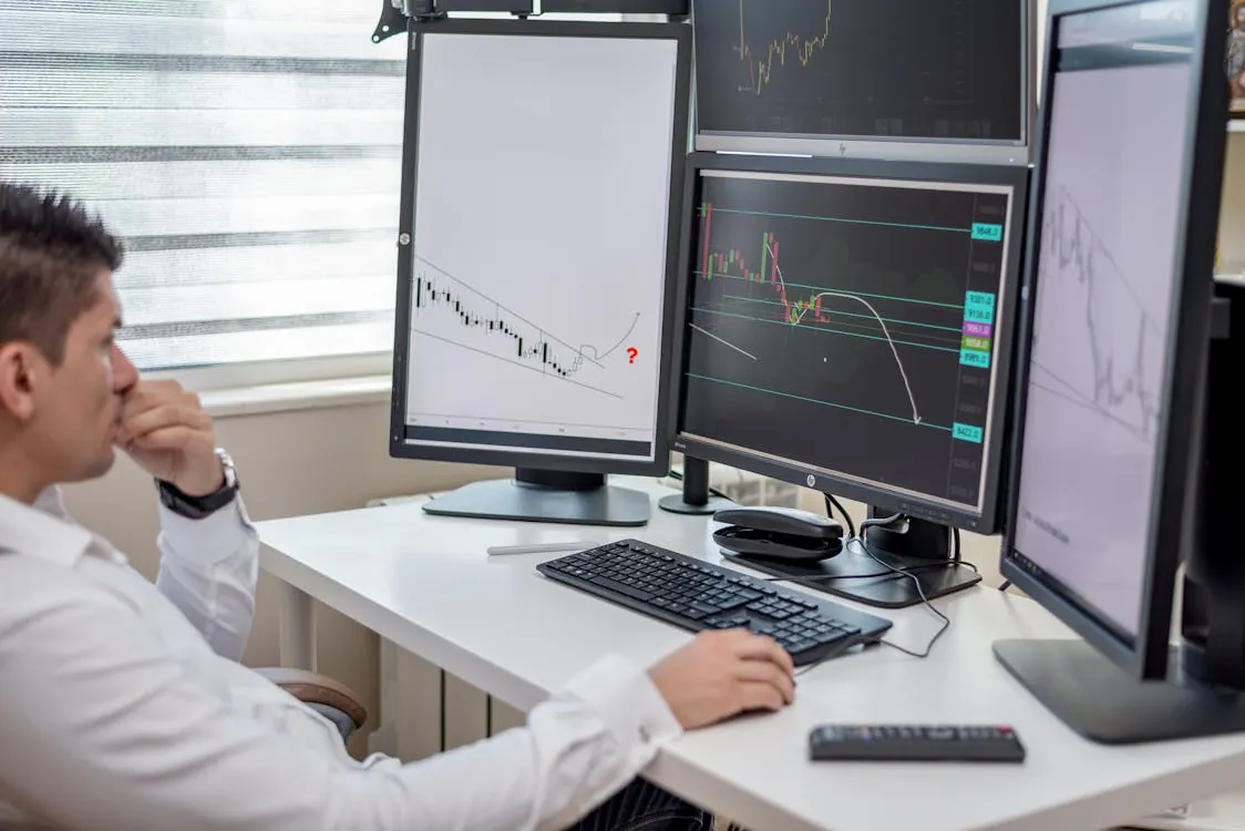 Financial analyst reviewing stock and crypto market charts