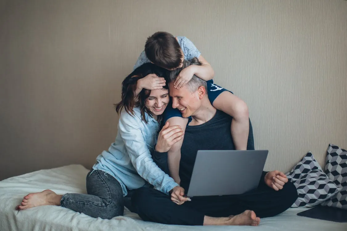 Happy digital nomad family bonding over a laptop in Spain