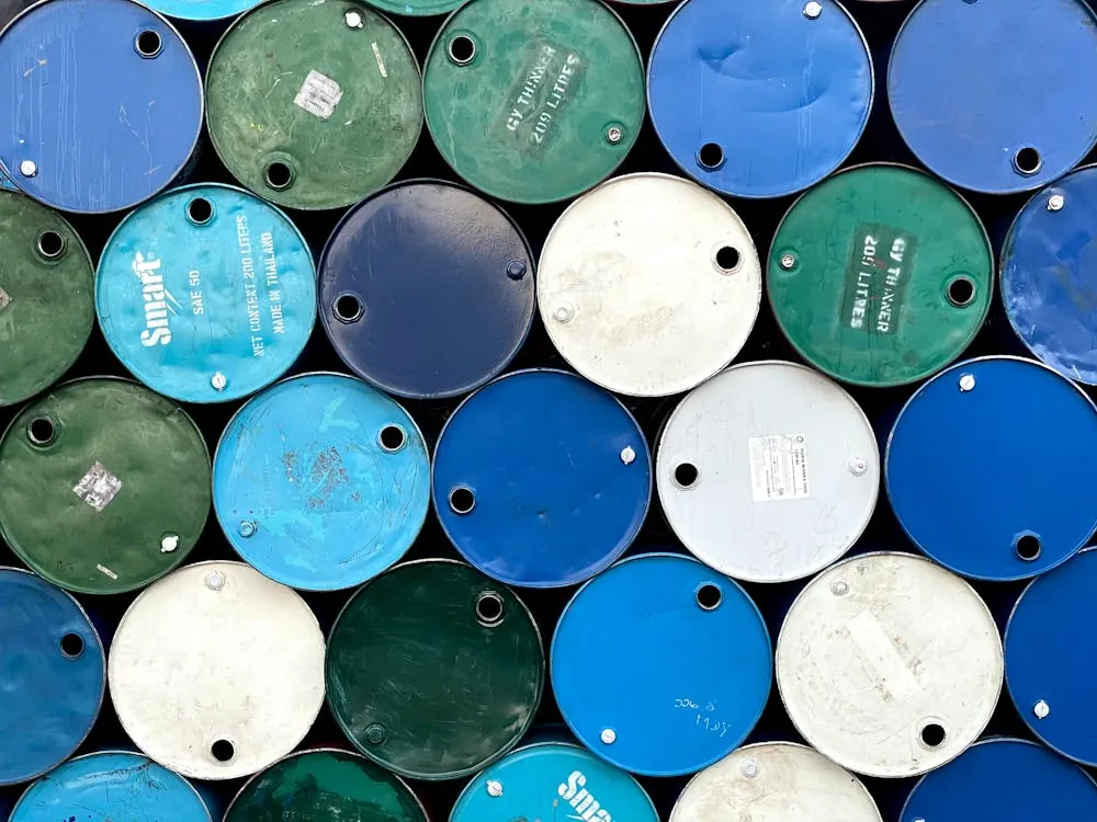 Stacked industrial barrels representing oil and energy markets