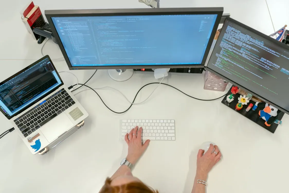 Developer workstation with multiple screens and coding interfaces