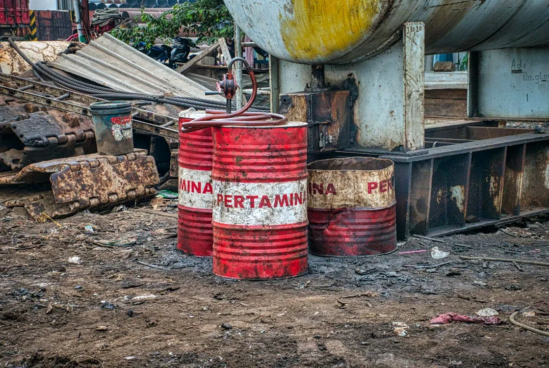Industrial oil barrels at a rugged fuel storage site