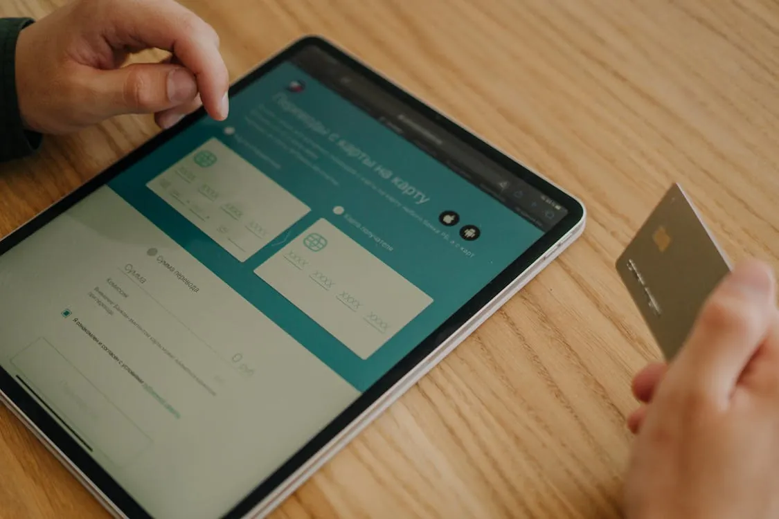 Hands making an online purchase on a tablet with a credit card, representing a fintech platform story