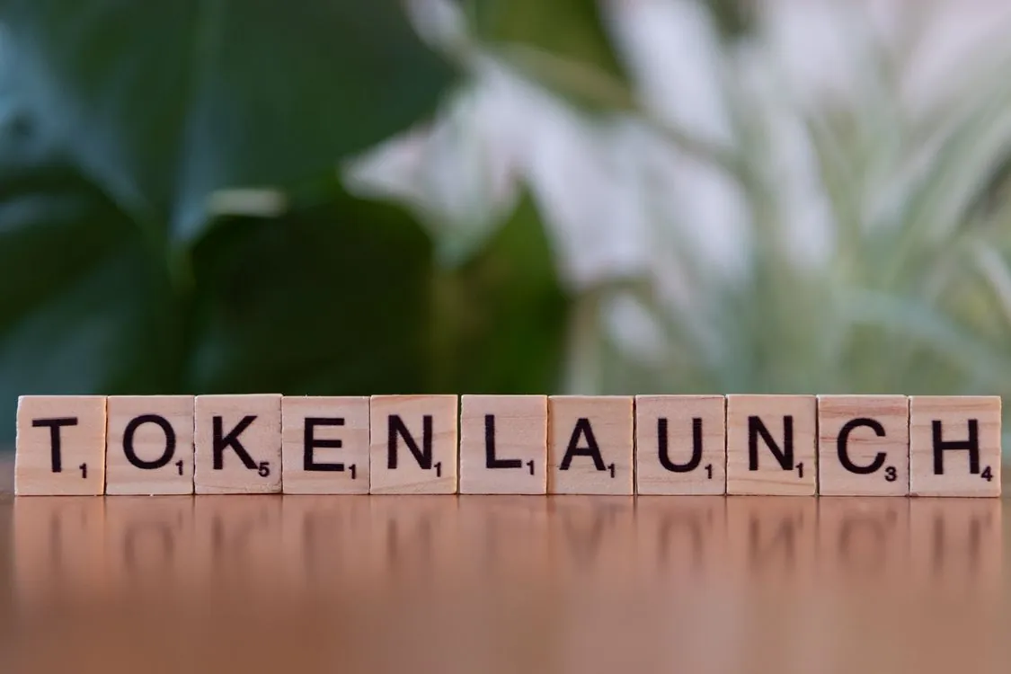 Scrabble tiles spelling 'Token Launch' on a vibrant green background, representing the concept of tokenization in language processing.