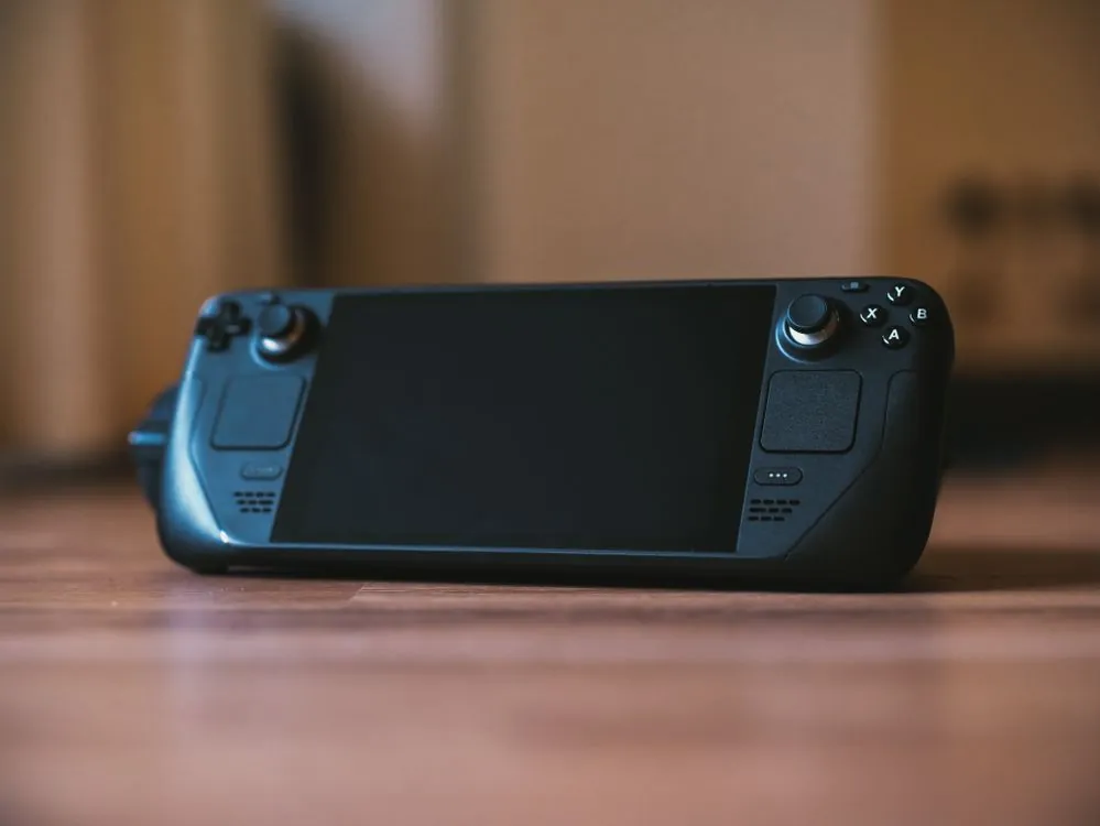Portable gaming device on table with game running on screen