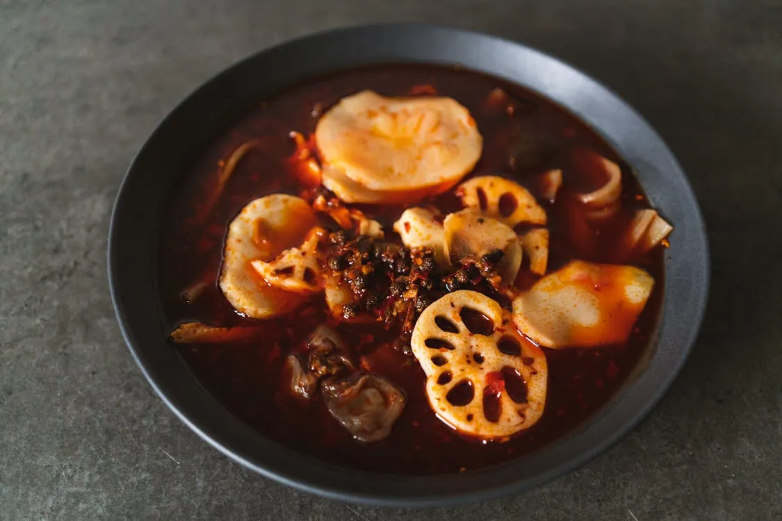 Sichuan spicy hotpot bubbling with chili peppers and Sichuan peppercorns