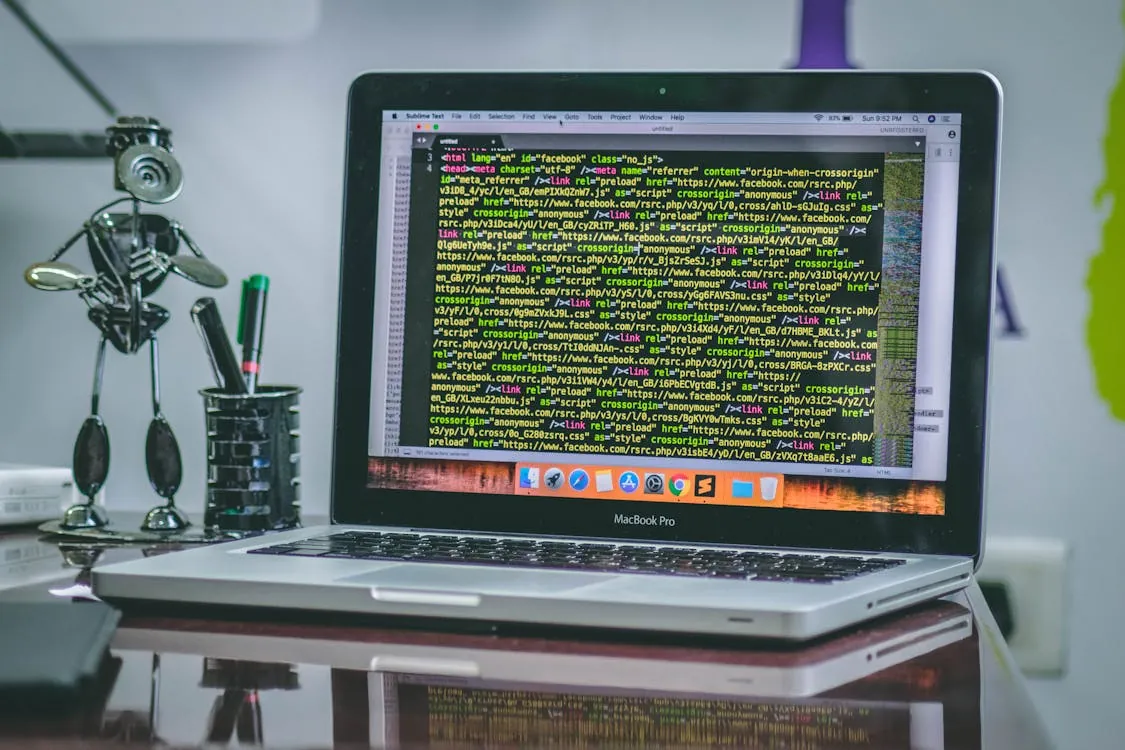 Software developer coding on MacBook with BBEdit open