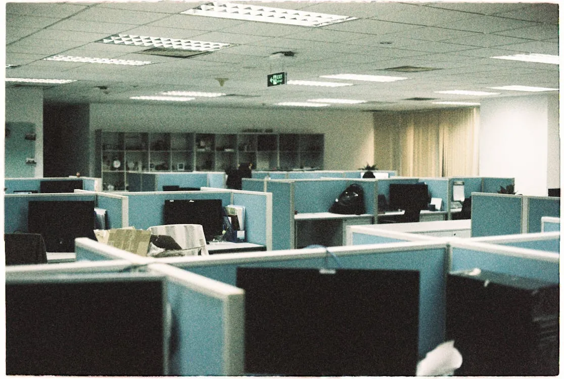 Empty office desk with cardboard box symbolizing layoffs