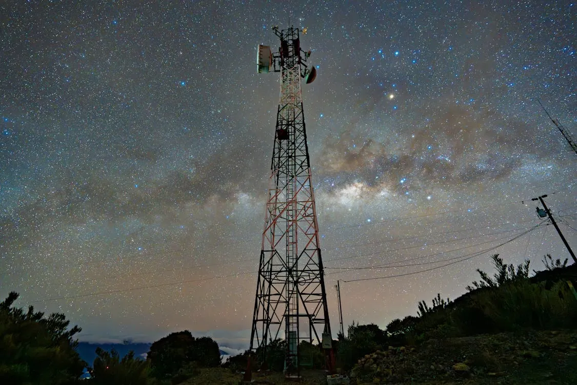 Communication tower under starry night sky