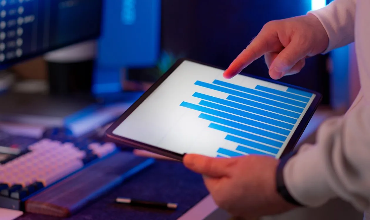 Business professional analyzing bar chart on tablet in office setting, highlighting data insights for RAG evaluation metrics.