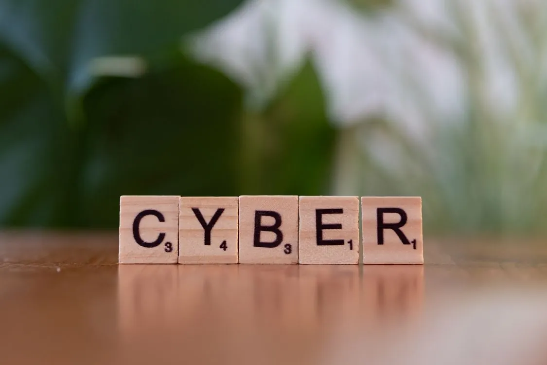 Wooden letter tiles spelling CYBER representing cybersecurity concept