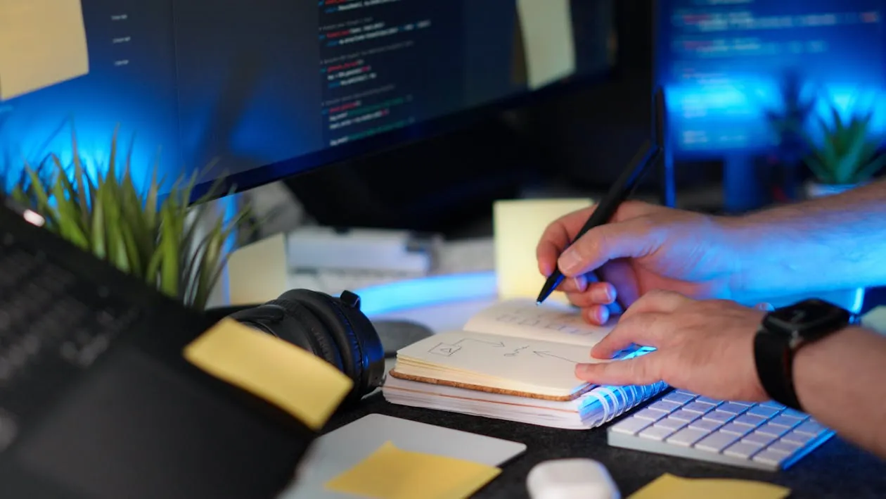 Software developer working on SQL workflow code on dual monitors