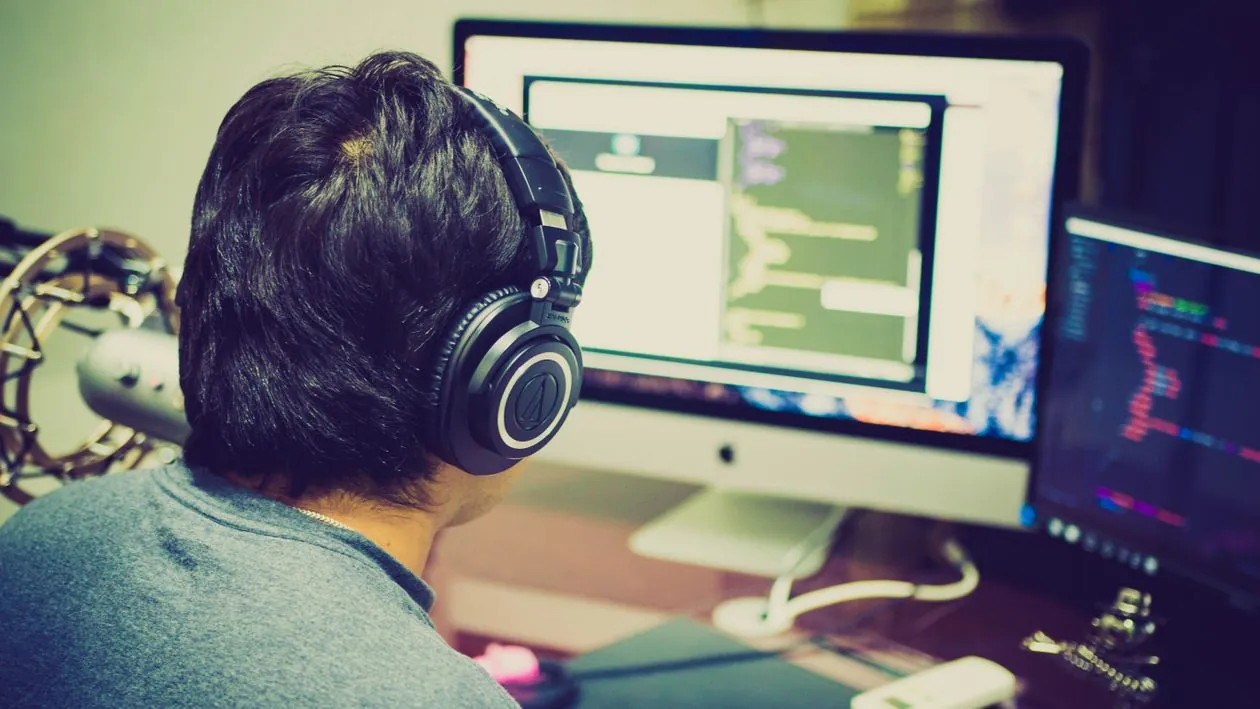 Indie game developer coding at a computer desk