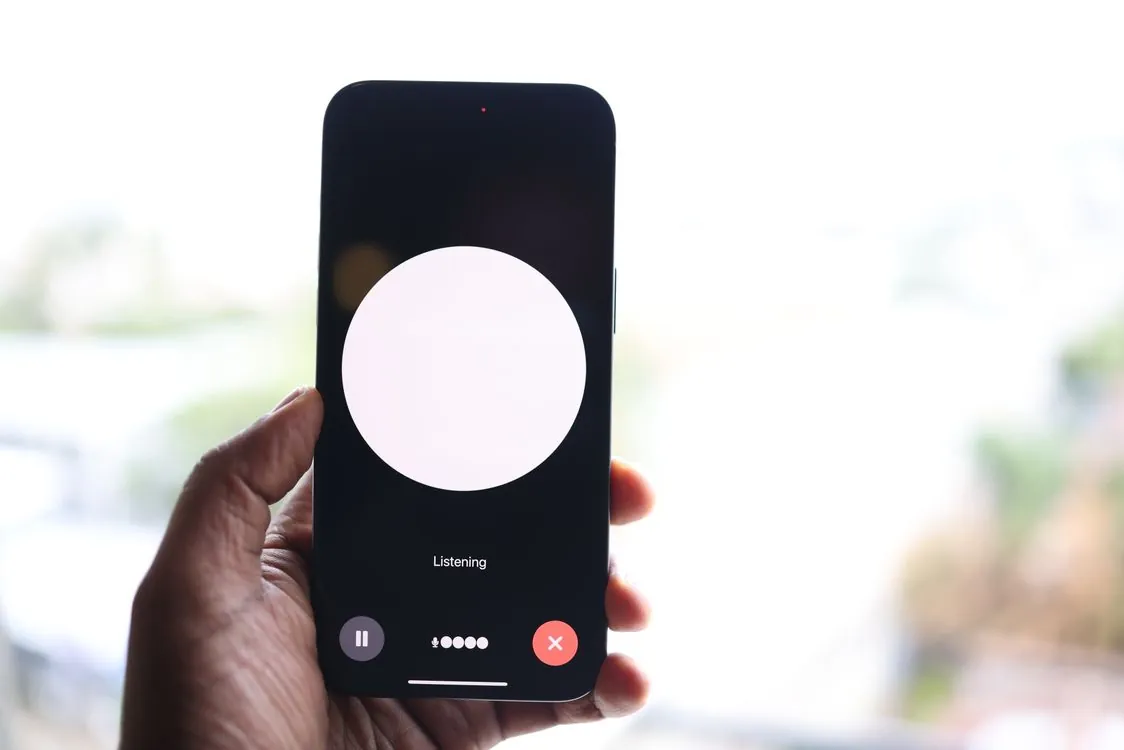 Hand holding smartphone with voice recording app active