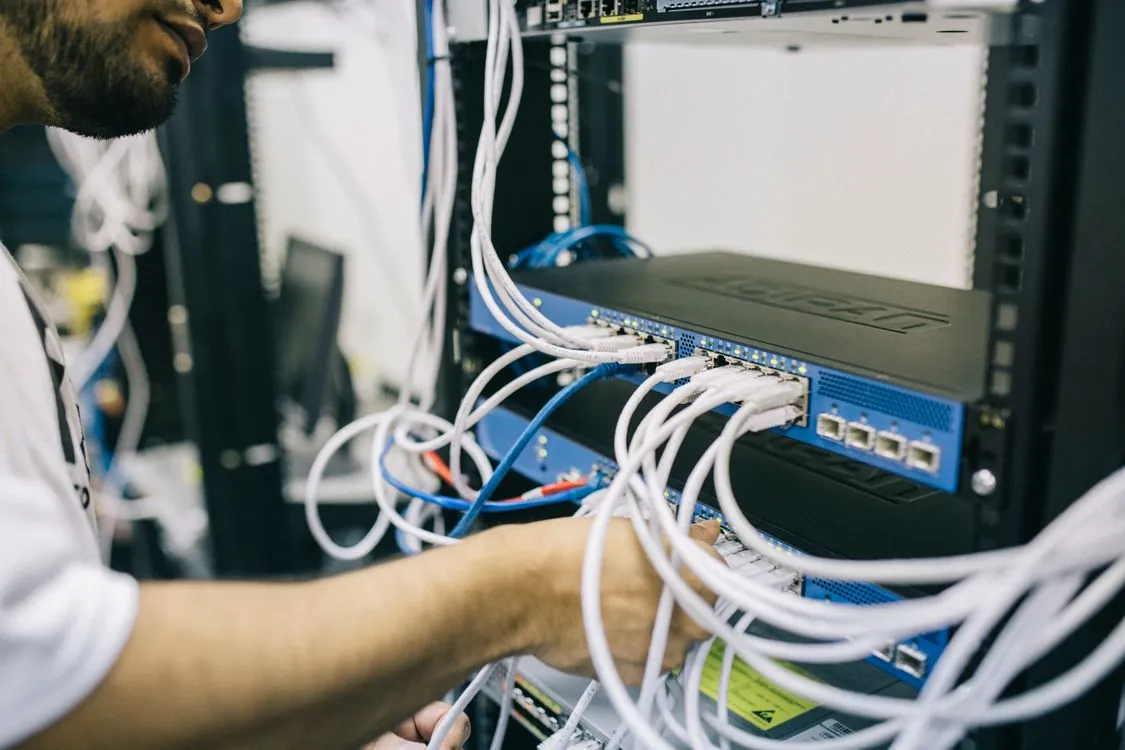 IT professional configuring network cables in server rack