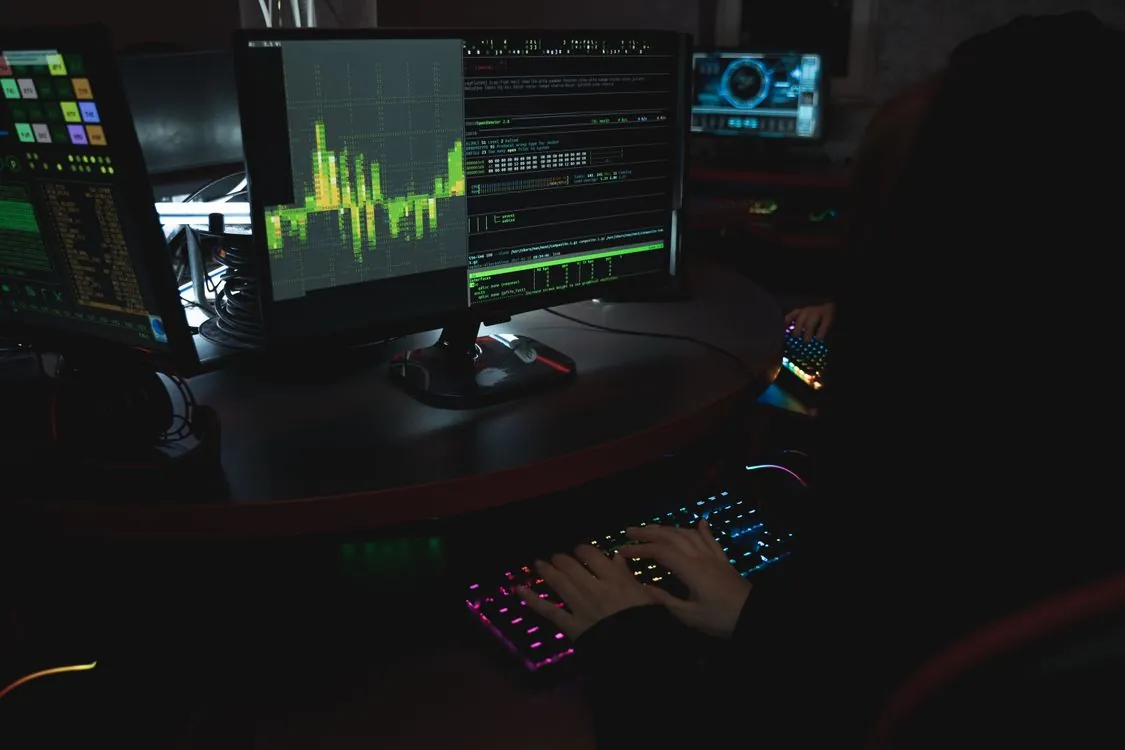 Security researcher working on code with multiple monitors showing vulnerability analysis