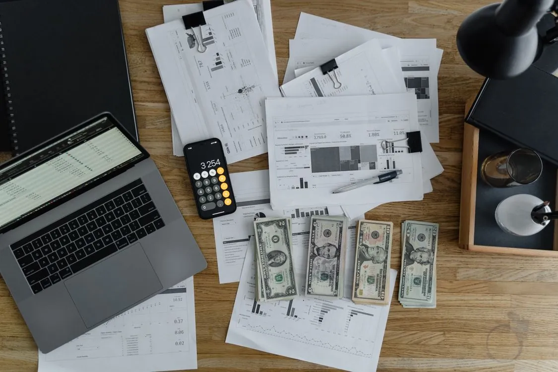 Technology cost analysis with charts and graphs on desk