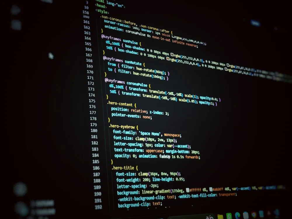 Developer coding game with JavaScript and HTML5 on computer monitor