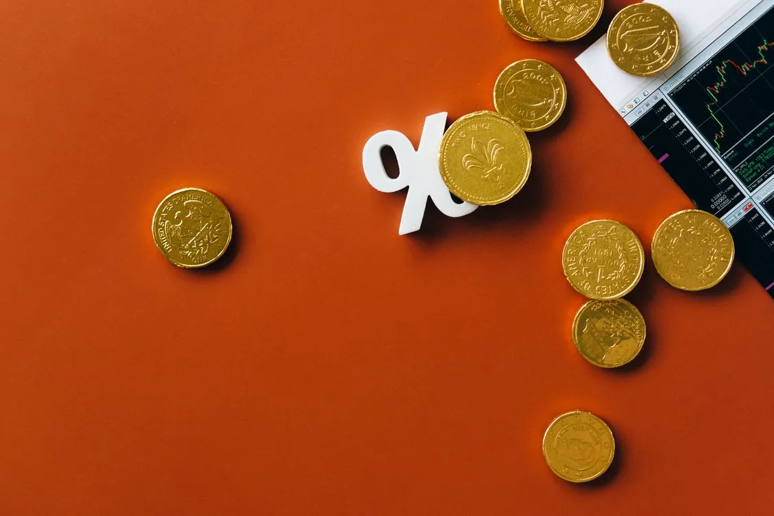 Gold coins with market chart and percentage symbol