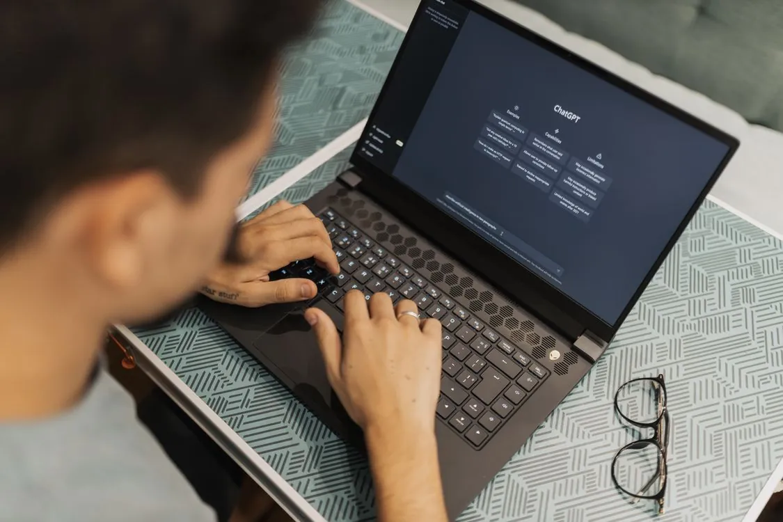 A person using a laptop representing AI beta testing and audit review