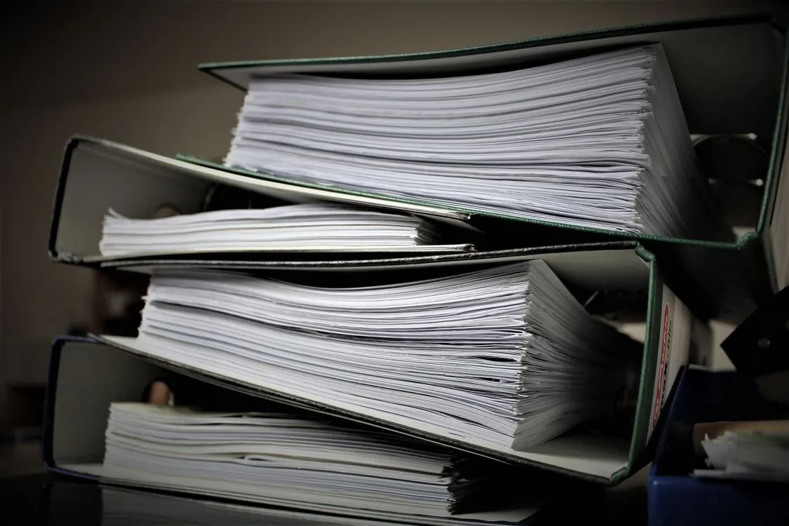 Close-up of stacked binders filled with documents representing enterprise knowledge management