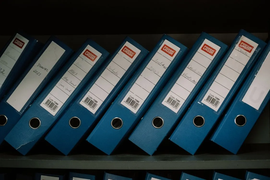 Neatly arranged office binders with classification labels for organized data management