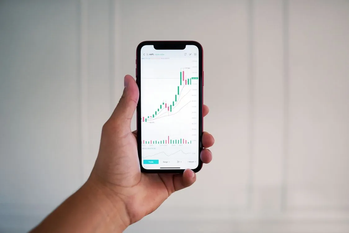 Mobile stock trading app used by an investor reviewing market charts