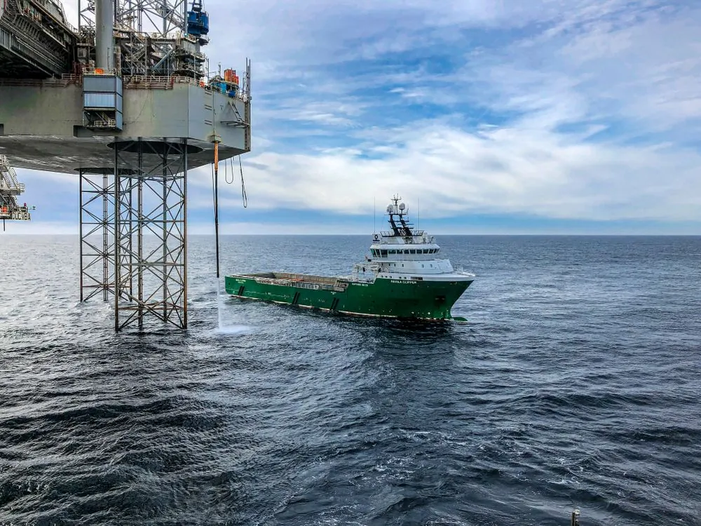 Offshore supply vessel and oil rig in open water representing the marine offshore sector