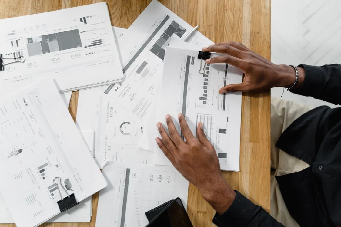 Financial analyst reviewing company financial statements and market data charts