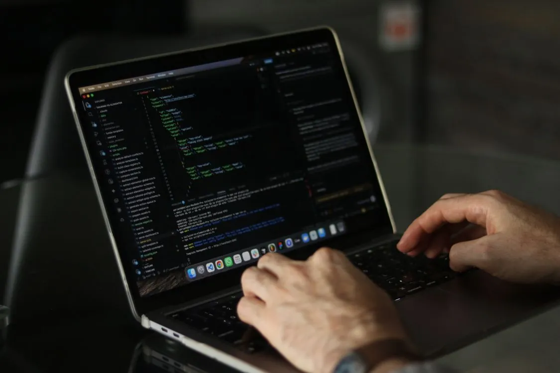 Developer using AI coding agent on laptop