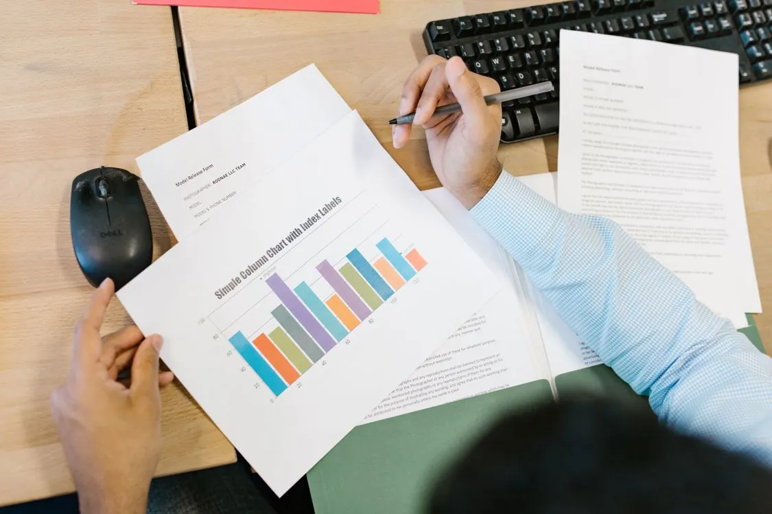 Analyst reviewing a bar chart and notes while validating structured output