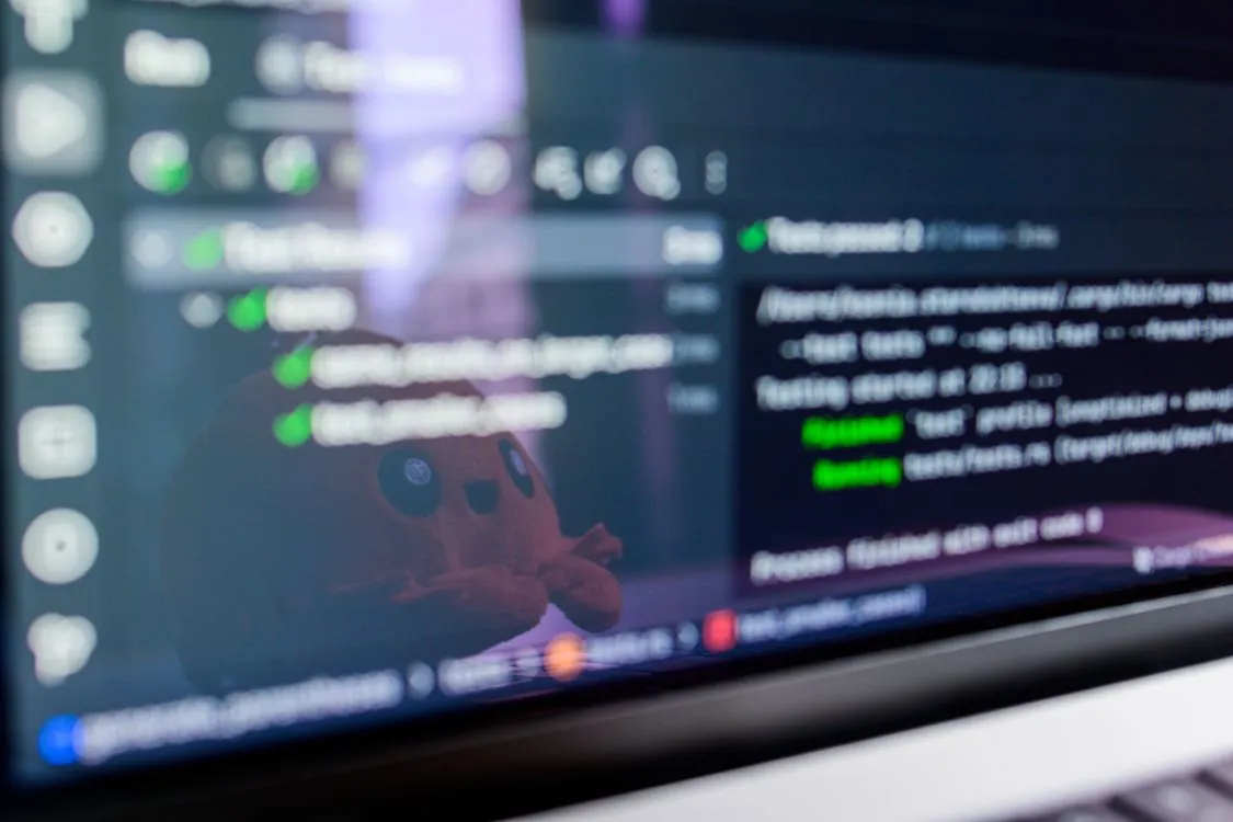 A software developer reviewing code on a laptop screen while working with an AI coding assistant