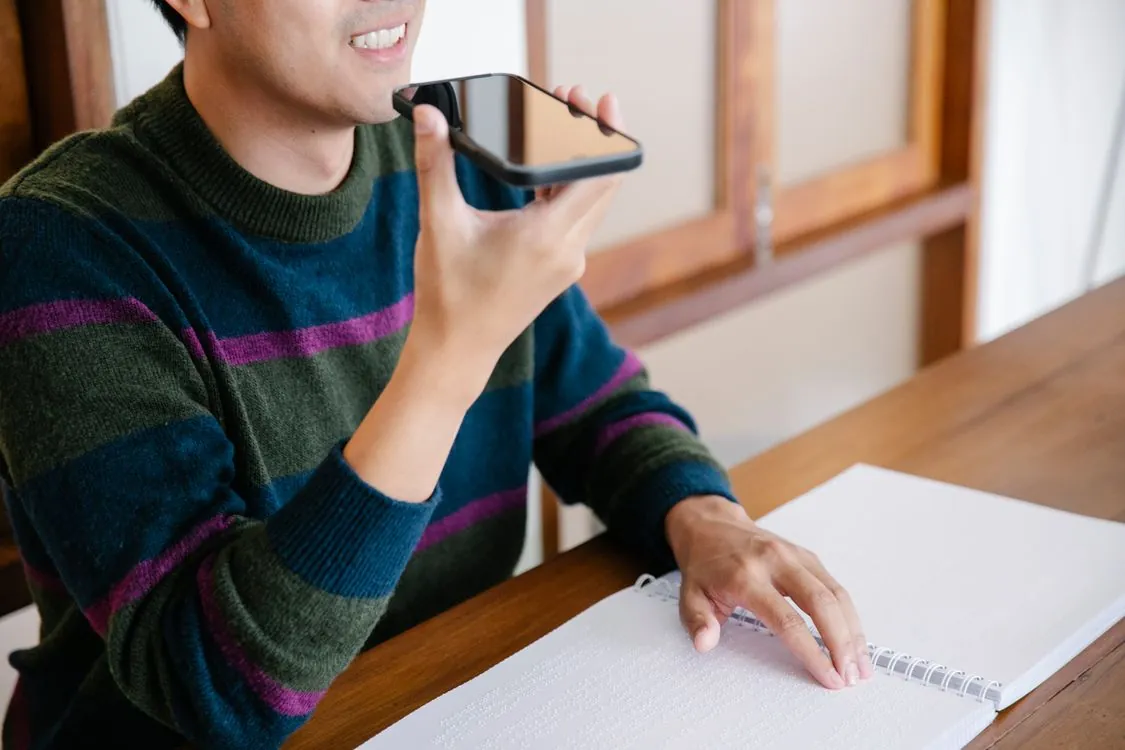 Person using a phone with a voice assistant at home