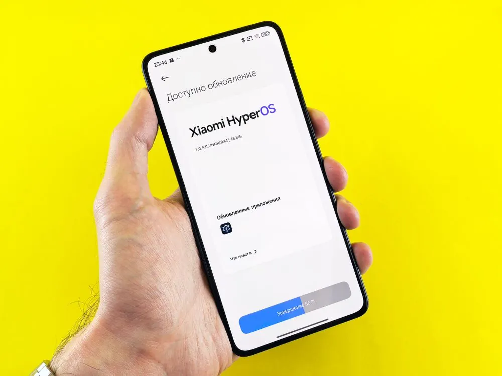 Hand holding iPhone showing system software update prompt