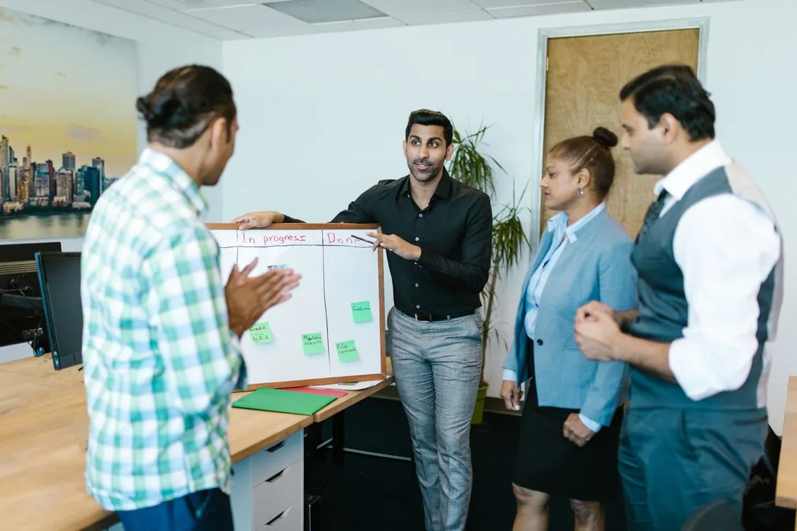 Team reviewing a project board that tracks prompt testing work in progress and done