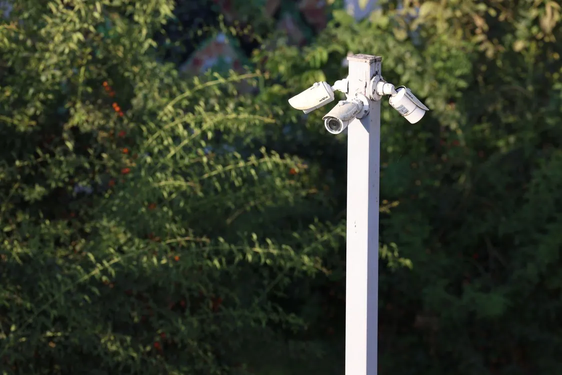 Outdoor security cameras mounted on a pole, representing the biometric surveillance layer in public spaces