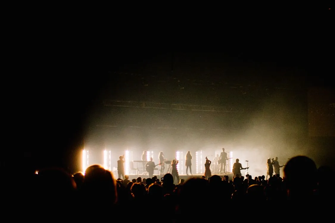 Crowd at a large live concert with stage lighting