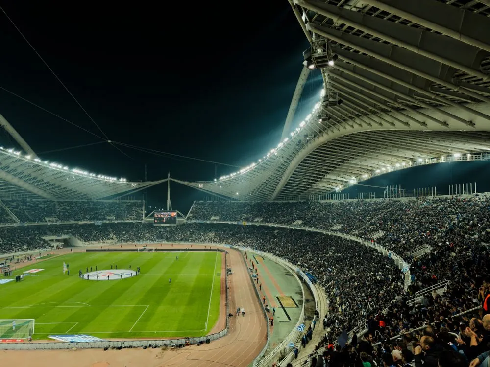 American football game under stadium lights at night
